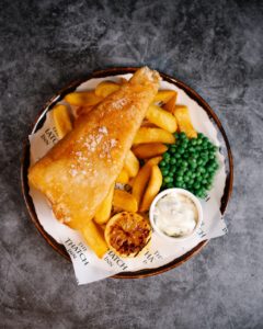 Fish and chips with peas and tartar sauce.